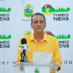 persona vestida de camisa amarilla, en frente de un backing