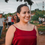 mujer de pie, sonriendo de vestido rojo de tiras